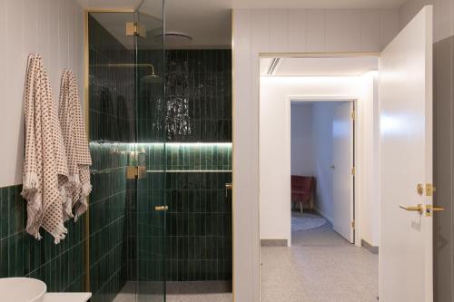 baño con ducha con azulejos verdes en Tamar Views, en Inveresk