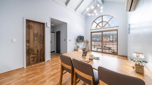 a dining room with a table and chairs and a window at Taean Atirans Beach Pension in Taean