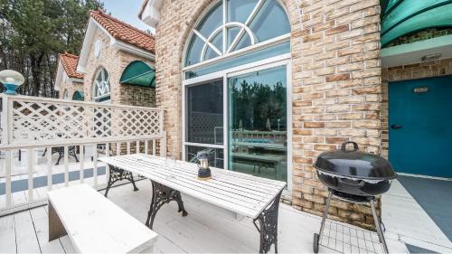a grill on a patio with a wooden table and bench at Taean Atirans Beach Pension in Taean