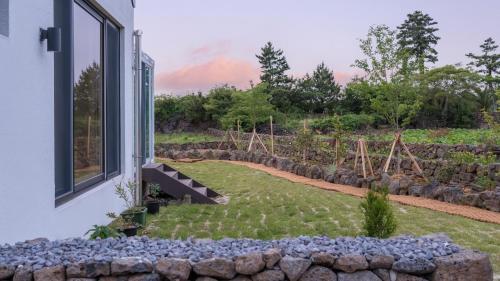 a view of a garden from the window of a house at Jeju moridarakbang pension in Jeju