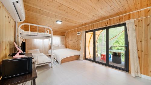 a room with a bed and a tv and a window at Gapyeong Soopia pension in Gapyeong