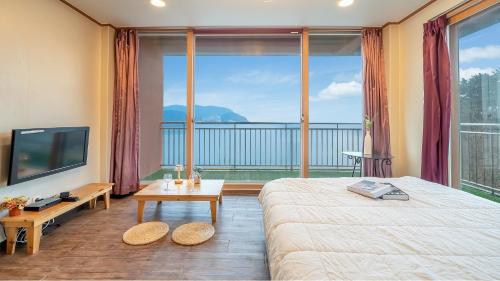 a bedroom with a bed and a large window at Daebudo green beach Pension in Ansan