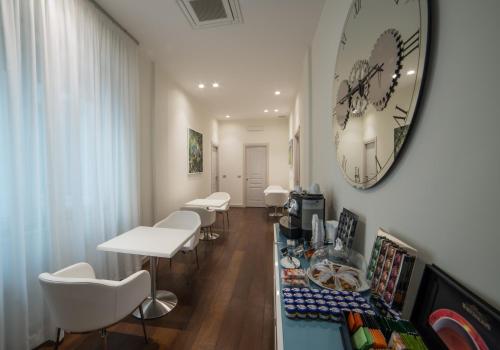 a waiting room with white chairs and a clock on the wall at Town House Morgana in Reggio Calabria