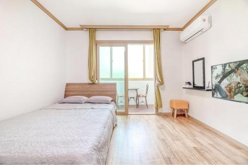 a bedroom with a bed and a table at Samcheok Greenhyang Pension in Samcheok