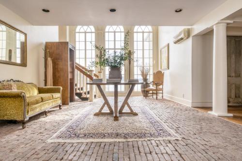 a living room with a table and a couch at River House by AvantStay Historic Secluded Estate on the Hudson River w Pool Sleeps 24 in Hudson