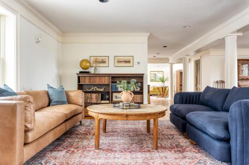 a living room with two couches and a coffee table at River House by AvantStay Historic Secluded Estate on the Hudson River w Pool Sleeps 24 in Hudson