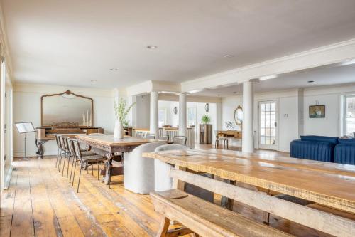 a living room with wooden tables and a blue couch at River House by AvantStay Historic Secluded Estate on the Hudson River w Pool Sleeps 24 in Hudson