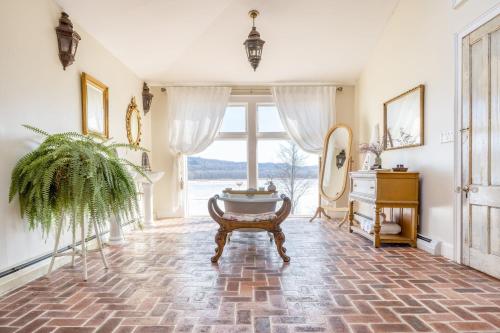 a living room with a large window and a table at River House by AvantStay Historic Secluded Estate on the Hudson River w Pool Sleeps 24 in Hudson
