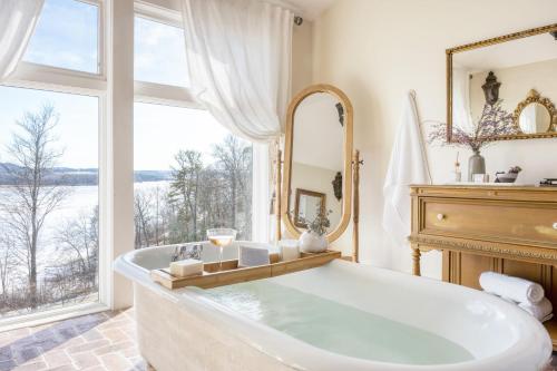 a large bathroom with a tub and a large window at River House by AvantStay Historic Secluded Estate on the Hudson River w Pool Sleeps 24 in Hudson