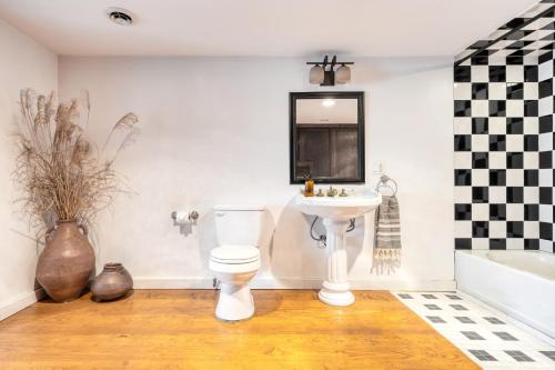 a bathroom with a toilet and a sink and a tub at River House by AvantStay Historic Secluded Estate on the Hudson River w Pool Sleeps 24 in Hudson