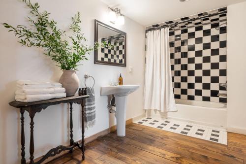 a bathroom with a black and white checkered shower curtain and a sink at River House by AvantStay Historic Secluded Estate on the Hudson River w Pool Sleeps 24 in Hudson
