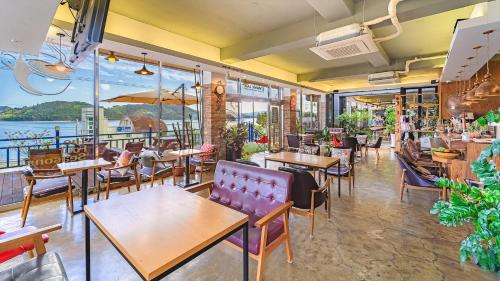a restaurant with tables and chairs and a view of the water at Namhae Spring, Summer, Fall, Winter Pet- in Namhae