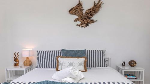 1 dormitorio con 1 cama blanca y 2 mesas en Sunshine Shack - Umina Beach, en Umina Beach 