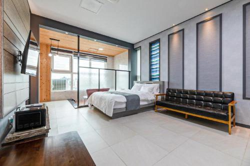 a bedroom with a bed and a couch at Buan TomynSpa Pension in Buan