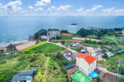 an aerial view of a house next to the ocean at Buan TomynSpa Pension in Buan