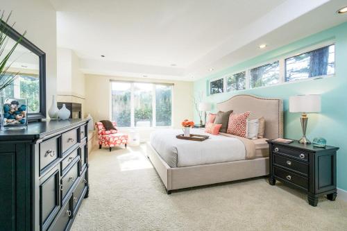 a bedroom with a bed and a dresser and windows at Villa Manzanita by AvantStay Hot Tub 1 Block to BeachTown Chefs Kitchen in Manzanita