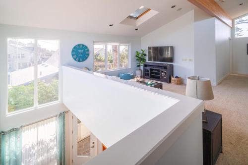 an open kitchen and living room with white walls and windows at Villa Manzanita by AvantStay Hot Tub 1 Block to BeachTown Chefs Kitchen in Manzanita