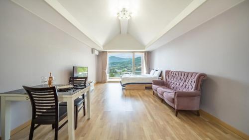a living room with a couch and a table and a chair at Gapyeong Yeonkkocchosu Pet Pension in Gapyeong