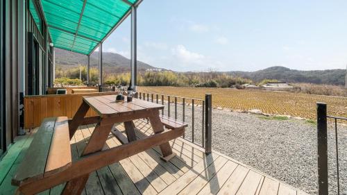 a wooden deck with a picnic table on the side of a house at Gyeongju Jayeon Pension in Gyeongju