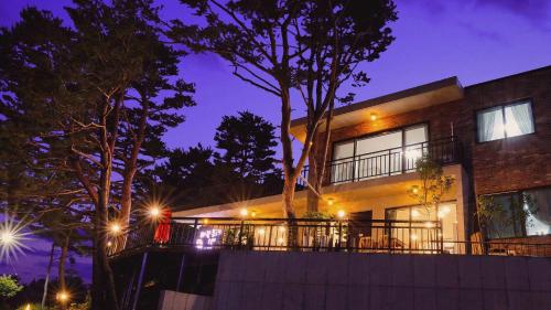 a house with lights on the side of it at night at Goseong Pinetree Pension in Goseong