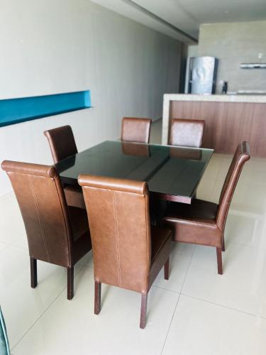 a dining room table and chairs with a glass top at Vista a Playa con Alberca en Blvd principal frente al Mar 3hab in Boca del Río