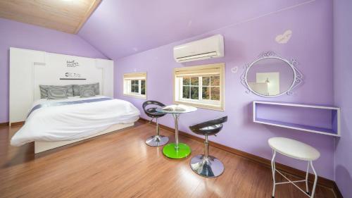 a purple bedroom with a bed and a mirror at Gapyeong ID pension in Gapyeong