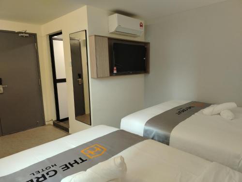 a hotel room with two beds and a tv at The great hotel greenhill in Ipoh