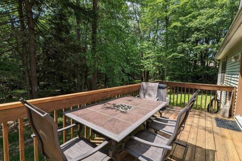 a wooden deck with a table and chairs on it at Chalet on Chalet by AvantStay Bright Cabin w Deck Fire Pit Near Lake in Lake Harmony