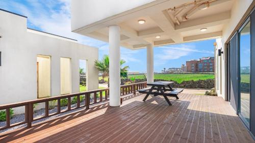 a patio with a picnic table on a balcony at casadelfino in jeju in Seogwipo