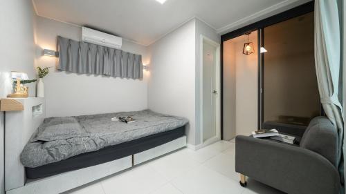 a small bedroom with a bed and a chair at Gyeongju Modern Pool Villa in Gyeongju