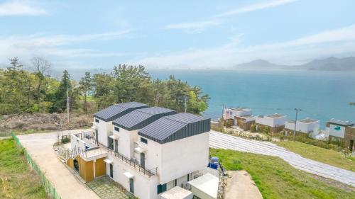 an aerial view of a house with solar panels on it at Namhae Byeol grigo namhae Pension in Namhae