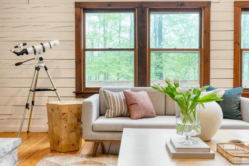 a living room with a couch and a telescope at Half Moon by AvantStay 4BR Cabin w Large Deck Yard w Patio Outdoor Dining in Great Barrington