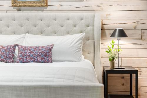a white bed with pillows and a table with a lamp at Half Moon by AvantStay 4BR Cabin w Large Deck Yard w Patio Outdoor Dining in Great Barrington