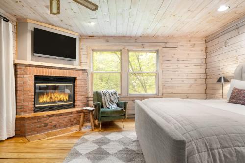 a bedroom with a fireplace and a bed and a tv at Half Moon by AvantStay 4BR Cabin w Large Deck Yard w Patio Outdoor Dining in Great Barrington