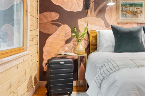 a bedroom with a suitcase next to a bed at Half Moon by AvantStay 4BR Cabin w Large Deck Yard w Patio Outdoor Dining in Great Barrington