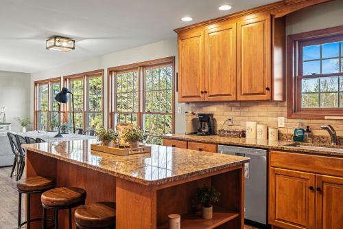 a kitchen with wooden cabinets and a large island at Lakers Pointe by AvantStay Lakefront Private Peninsula Hot Tub Game Room in Long Pond