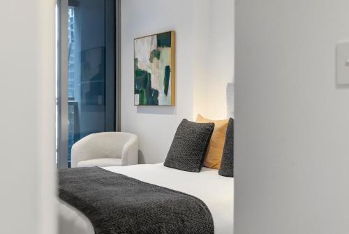 un dormitorio con una cama y una silla en New Central CBD, Pool, Gym, Wifi, en Melbourne