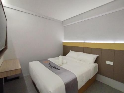 a bedroom with a white bed with two candles on it at The great hotel greenhill in Ipoh