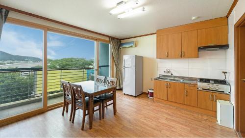 a kitchen with a table and chairs and a large window at Ganghwa Dondaemoru pension in Incheon