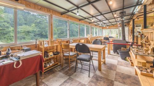 a room with a table and chairs and windows at Gapyeong Namueuikkum pension in Gapyeong