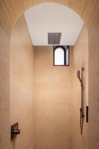 a bathroom with a shower with a ceiling at The Chedi Hegra, AlUla in AlUla