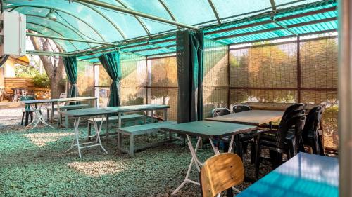 a group of tables and chairs in a greenhouse at Daebudo Banditbul Pension in Ansan