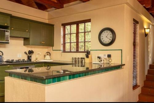 una cocina con un reloj grande en la pared en Clarens Charm, en Clarens