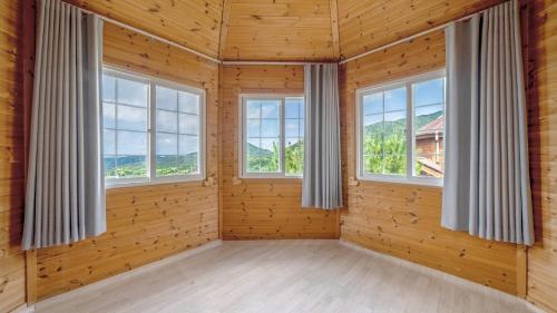 a room with three windows in a wooden house at Paju Sugavill Agyeon dongban Pension in Paju