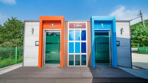 an orange and blue phone booth with two doors at Paju Sugavill Agyeon dongban Pension in Paju