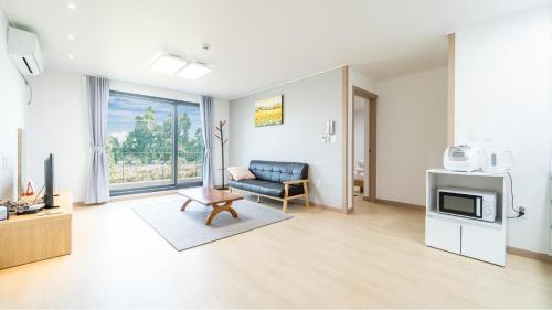 un soggiorno con un divano e una TV di Jeju ChunJaNe Pension a Seogwipo