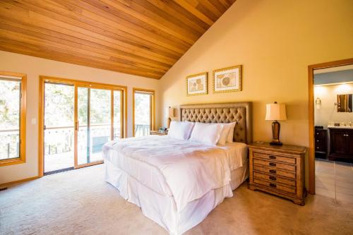a bedroom with a large bed with a wooden ceiling at Sunriver by AvantStay Cozy Mountain Home w Indoor Pool and Hot Tub in Sunriver
