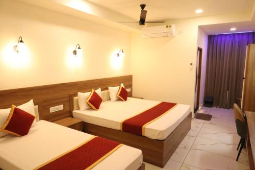 a hotel room with two beds in a room at Shanthi Tourist Home in Pathanāmthitta