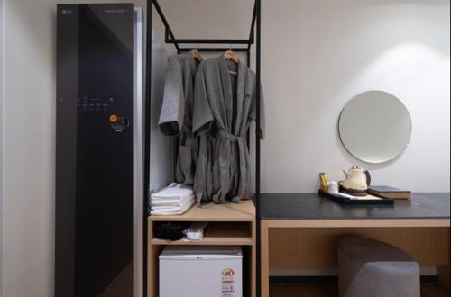 a room with a closet with a desk and a mirror at No25 Hotel Naeoe in Gimhae
