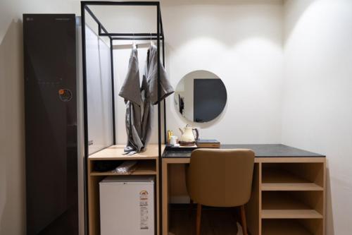 a desk with a mirror and a chair in a room at No25 Hotel Naeoe in Gimhae